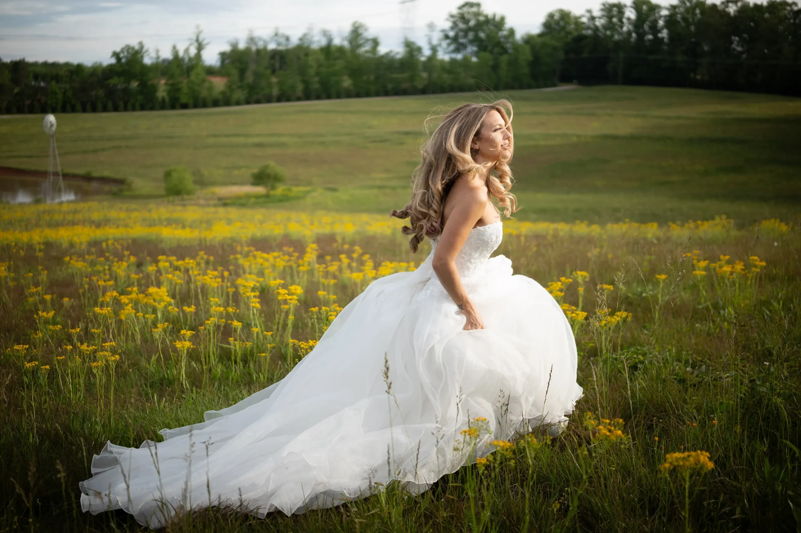 Cinematic bridal portrait with flowing hair in a field at The Venue at Far Out Farms, Landrum, SC.