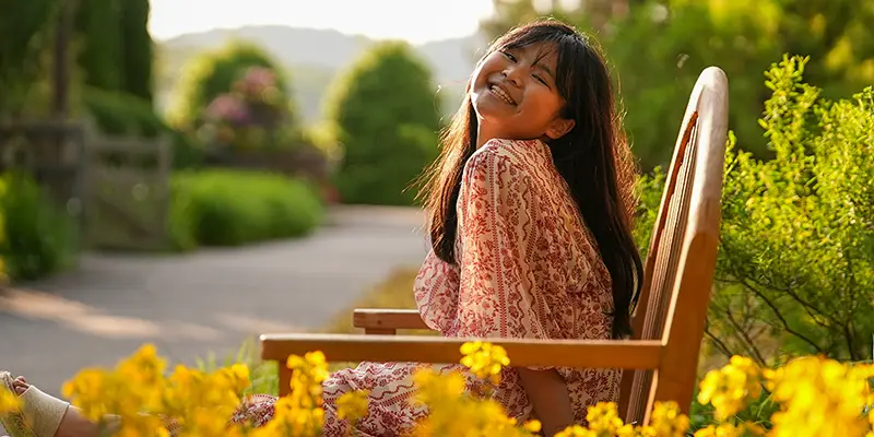 Young girl laughing in a flower garden